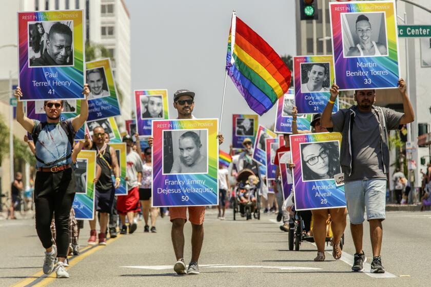 Marchers in the Orange County LGBT Pride parade in Santa Ana on Saturday carry portraits of the 49 LGBT victims of the Orlando, Fla., attack.