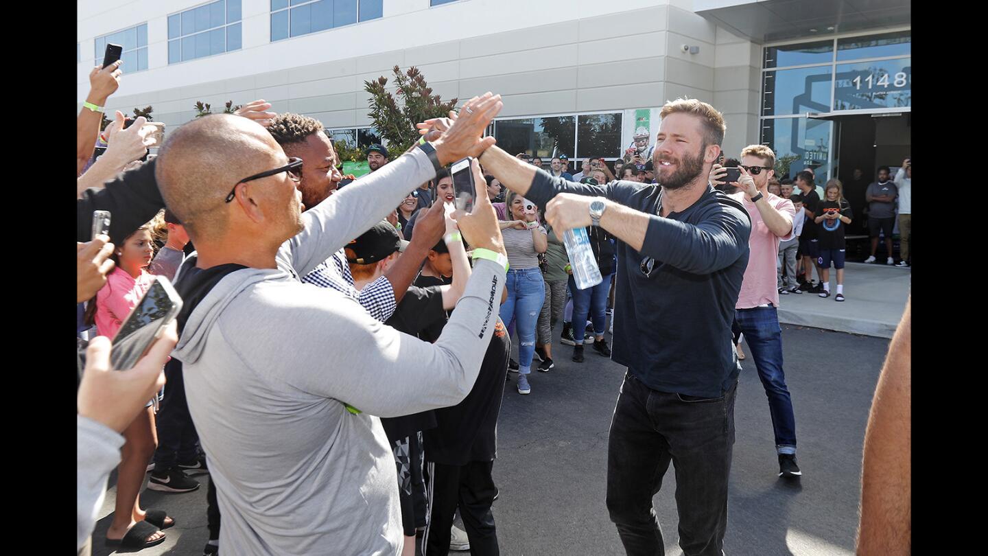 Julian Edelman, right, is greeted by fans at United Sports Brands headquarters in Fountain Valley on Tuesday. Edelman, the Super Bowl LIII MVP, uses the company's Cutters Gloves as a wide receiver for the New England Patriots.