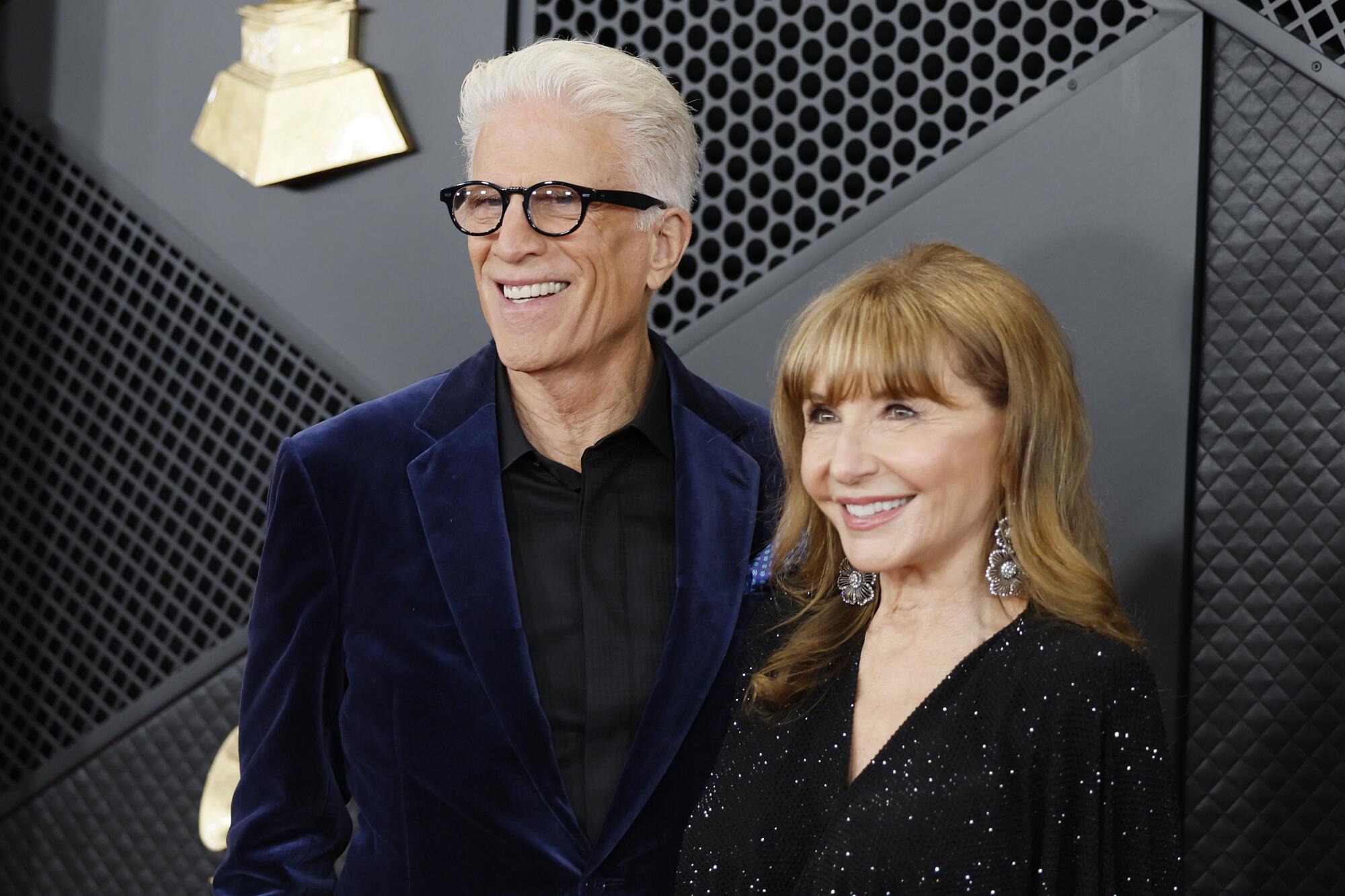 Ted Danson in a blue velvet suit and Mary Steenburgen in a shiny black dress 