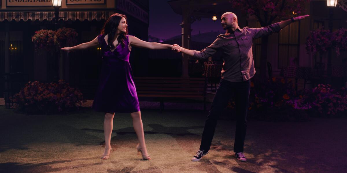 Cecily Strong and Keegan-Michael Key join hands while dancing in a scene from "Schmigadoon!" 