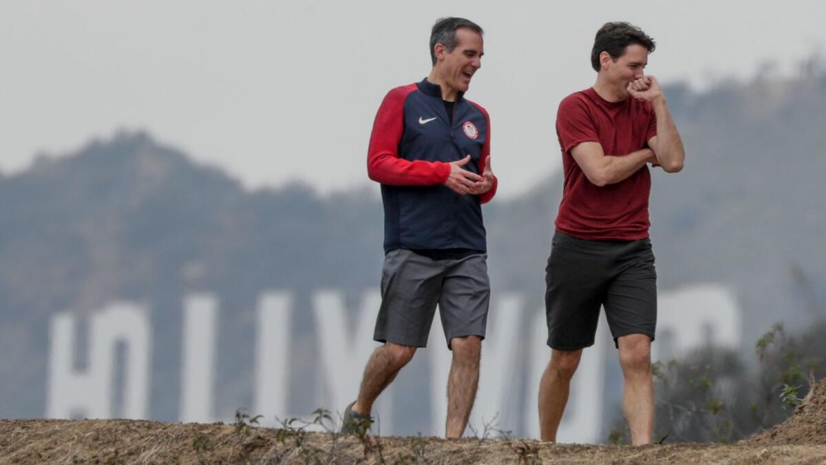 Haze blurred the Hollywood sign as winter finally arrived in time for a short hike from the Griffith Observatory on Saturday for Los Angeles Mayor Eric Garcetti, left, and visiting Canadian Prime Minister Justin Trudeau.