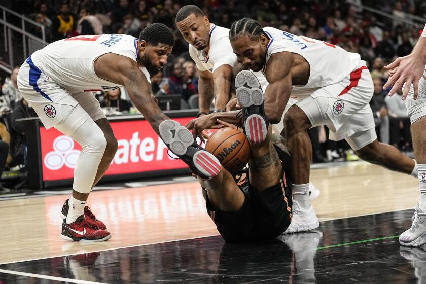 Atlanta Hawks forward John Collins (20), center, battle Los Angeles Clippers from left; Paul George (13), Norman Powell (24) and Kawhi Leonard (2) for the ball during the second half of an NBA basketball game Saturday, Jan. 28, 2023, in Atlanta. (AP Photo/John Bazemore)