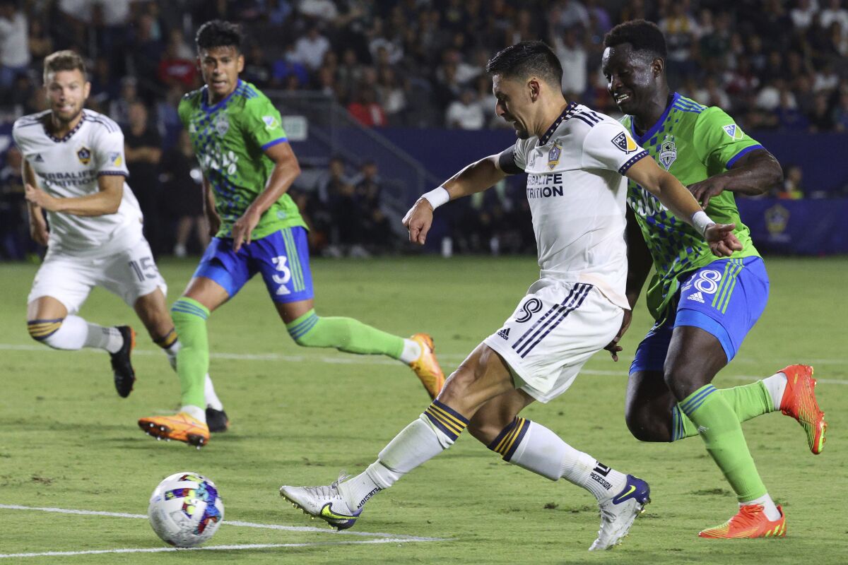 Galaxy midfielder Mark Delgado, center right, takes a shot during a draw against the Seattle Sounders on Aug. 19.