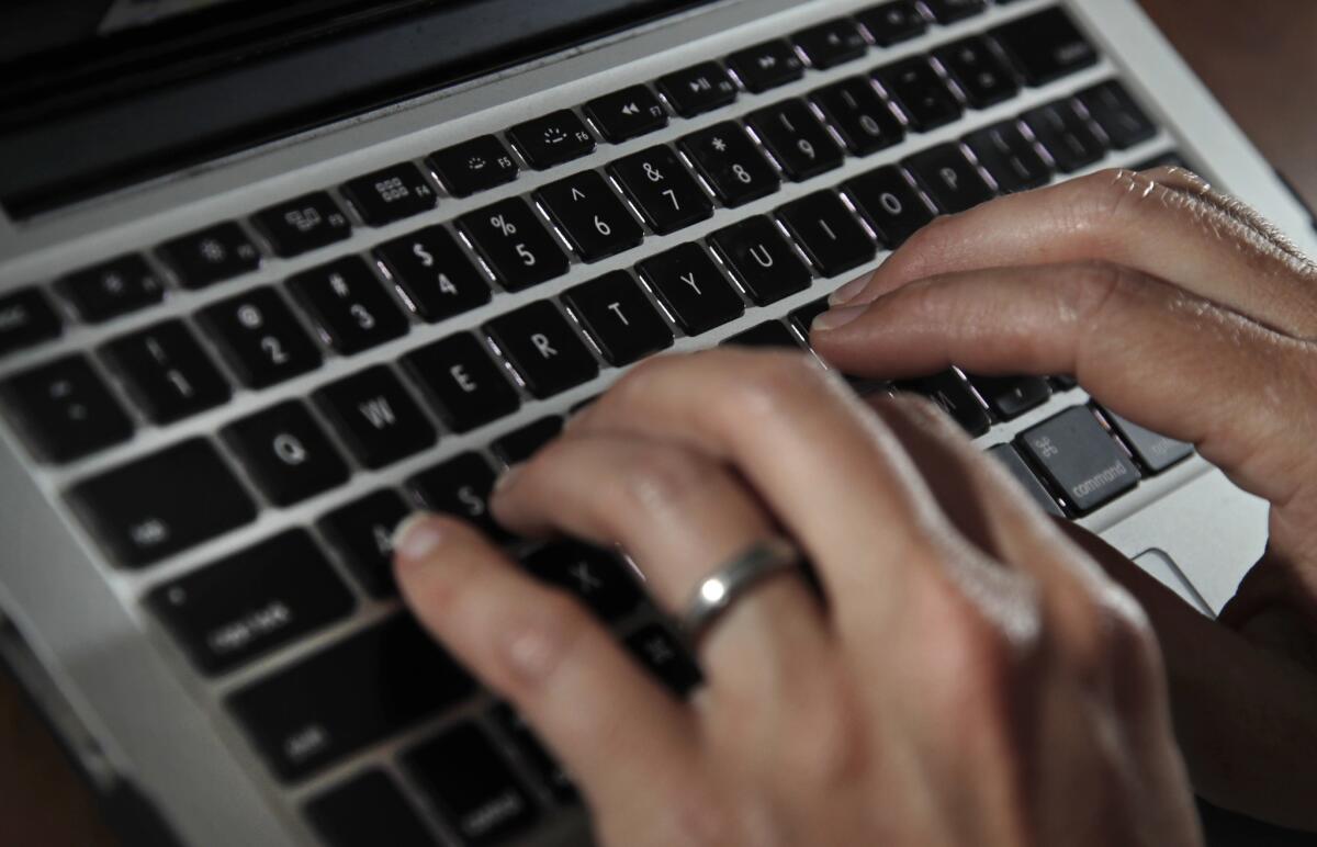 Fingers type on a computer keyboard.