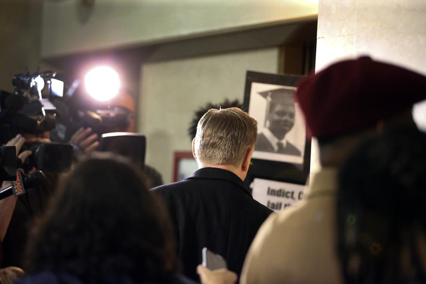 The Rev. Michael Pfleger, center, pastor at St. Sabina Church, heads to the elevators after refusing to take questions from reporters following a meeting with Mayor Rahm Emanuel at City Hall in Chicago on Nov. 23, 2015. The mayor discussed the impending release of a video showing Laquan McDonald being shot and killed by a Chicago police officer.