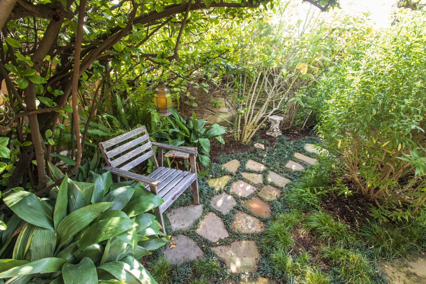 A stone path in a garden next to a chair