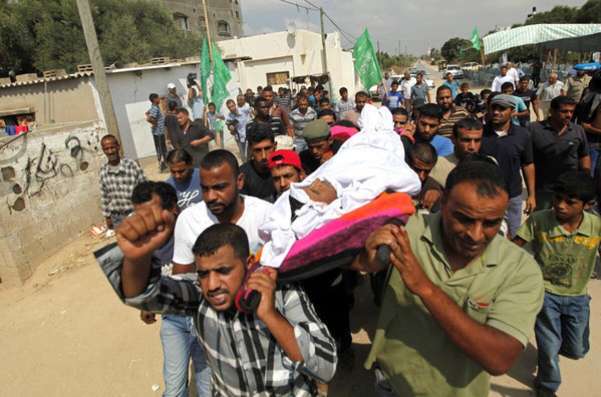 Palestinians carry the body of Hiwashel Abu Hiwashel, 36, who was killed Monday by Israeli soldiers, during his funeral Tuesday in central Gaza Strip.