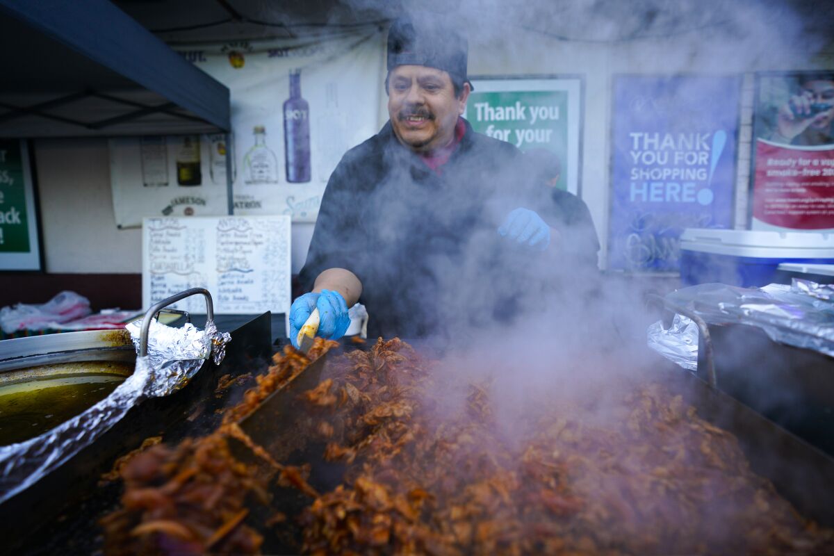 Teodoro Jimenez cooks carne asada on the grill to make fresh tacos at his business, Blue Fire Bliss.