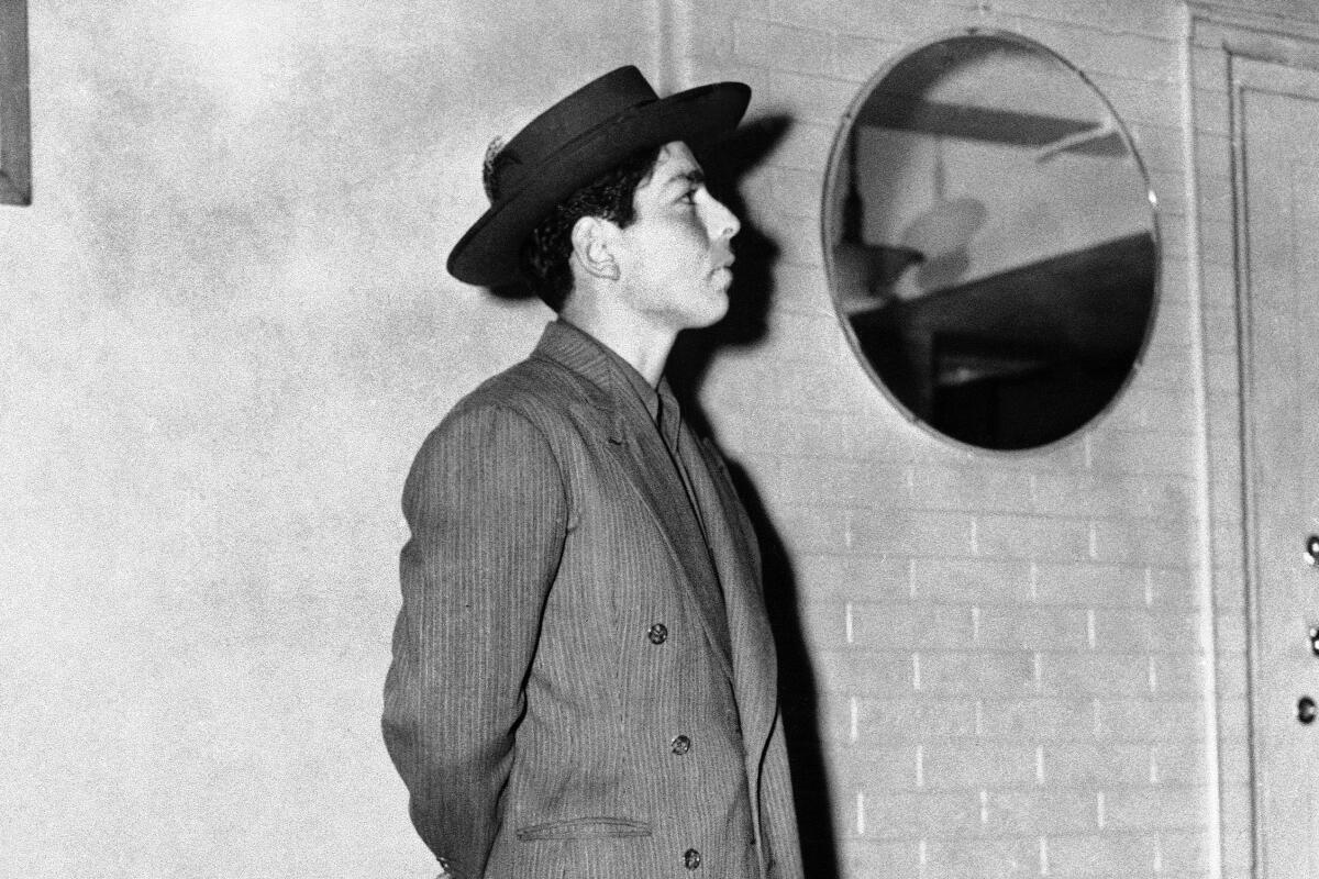 A man stands wearing a zoot suit