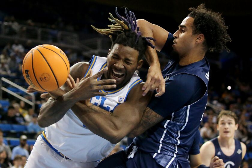 LOS ANGELES, CALIF. - DEC. 21, 2022. UCLA Bruins forward Kenneth Nwuba fights for control of the ball.