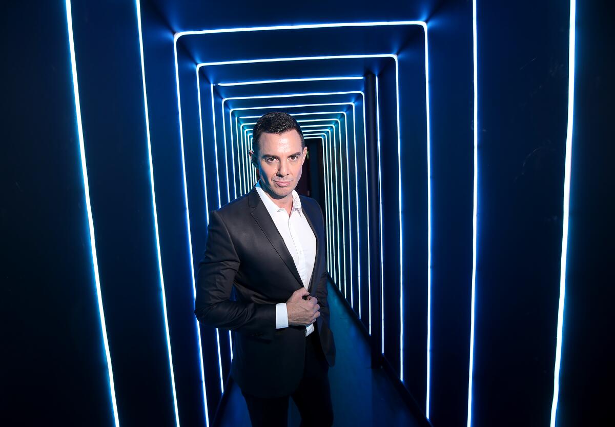 Owner Luke Nero stands in a neon tunnel at Strut Bar & Club, which will open soon at 719 W. 19th St. in Costa Mesa. The venue will feature disco balls and a neon 1980s nightclub feel.
