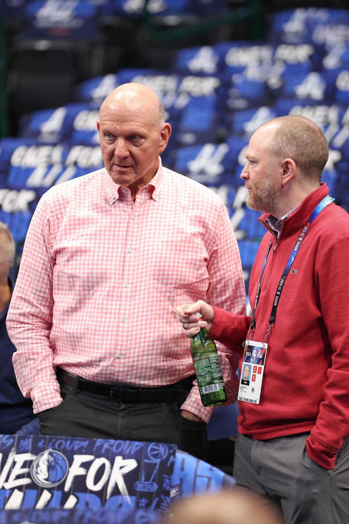 Clippers owner Steve Ballmer, left, talks to president of basketball operations Lawrence Frank before a playoff game in April