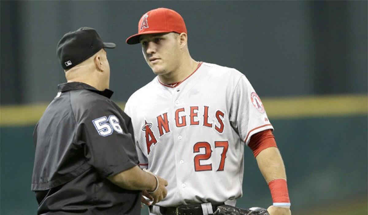 Angels outfielder Mike Trout talks with umpire Eric Cooper during the first inning of a game against the Houston Astros on April 6.