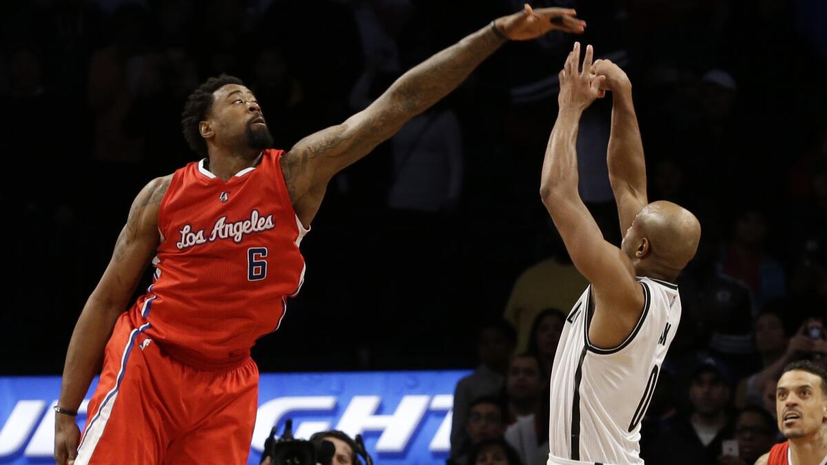 Clippers center DeAndre Jordan, left, tries to block a shot by Brooklyn Nets guard Jarrett Jack during the Clippers' 102-100 loss Monday.