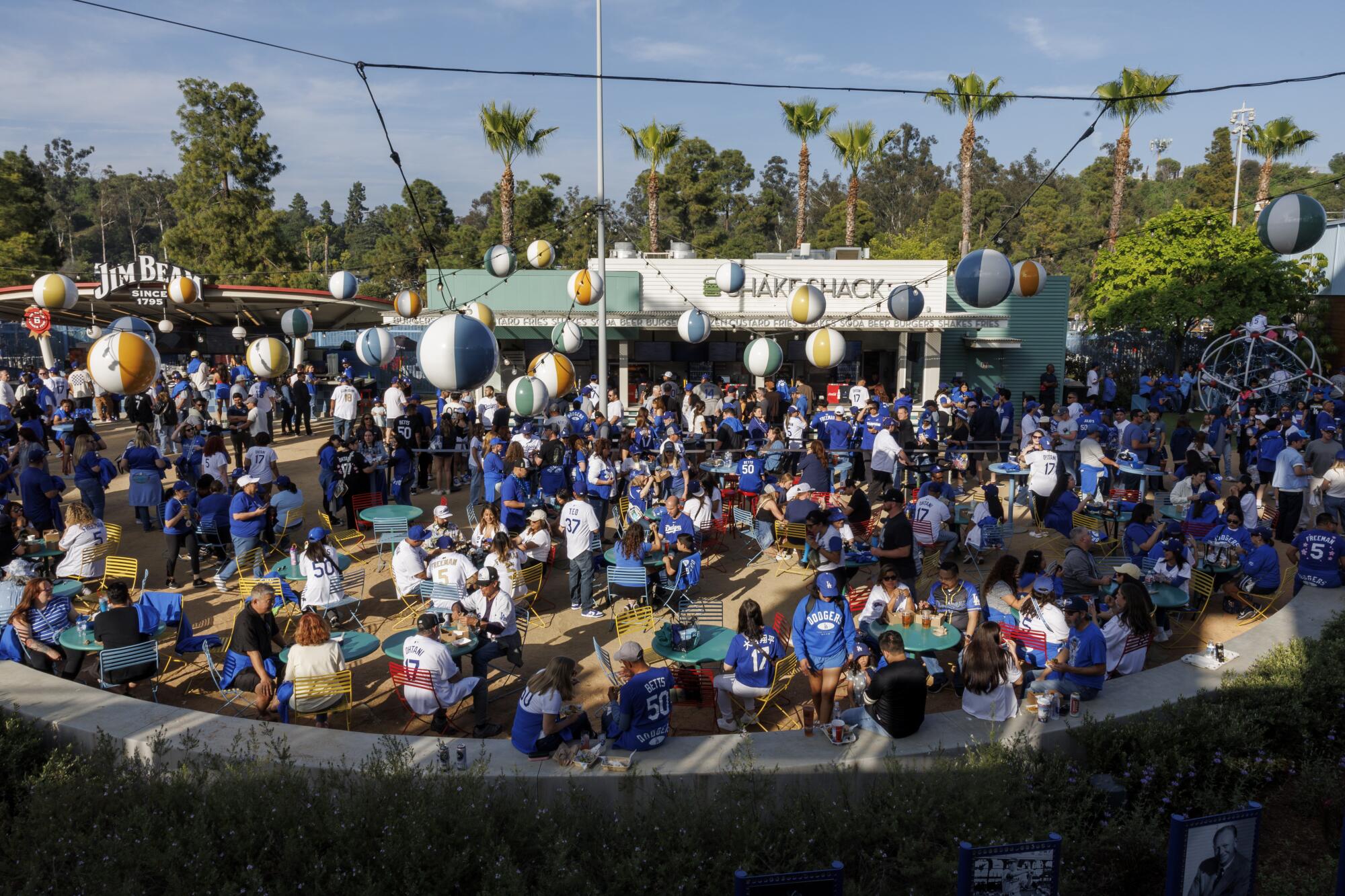 Dodgers fans enjoy concession stand food in the center field plaza at Dodger Stadium before a game in April.