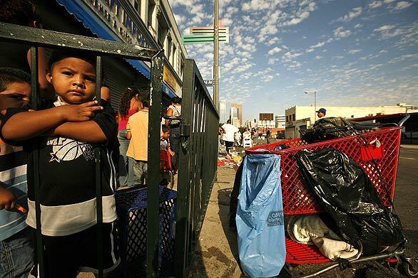 SPRUCING UP: Sebastian Salazar, 2, of Los Angeles waits with his family in a line that stretched around the block for the Fred Jordan Mission's "20th Annual Back-to-School Giveaway." Kids received shoes from Foot Locker as well as clothing, school supplies and haircuts during the event.