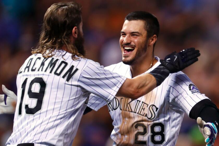 Colorado Rockies' Charlie Blackmon, left, hugs Nolan Arenado after Arenado's single drove in Blackmon with the winning run, off New York Mets relief pitcher Hansel Robles during the ninth inning of a baseball game Tuesday, Aug. 1, 2017, Denver. The Rockies won 5-4. (AP Photo/David Zalubowski)