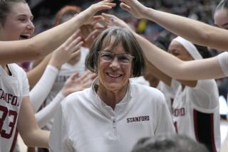 Stanford coach Tara VanDerveer smiles as players celebrate her 1,202nd victory as a college coach.