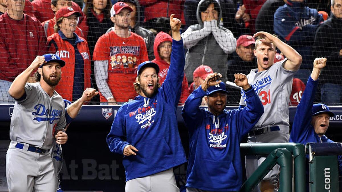 Dodger players and coaches celebrate after pinch-hitter Carlos Ruiz delivered a run-scoring single to take the lead over the Nationals in the seventh inning of Game 5.