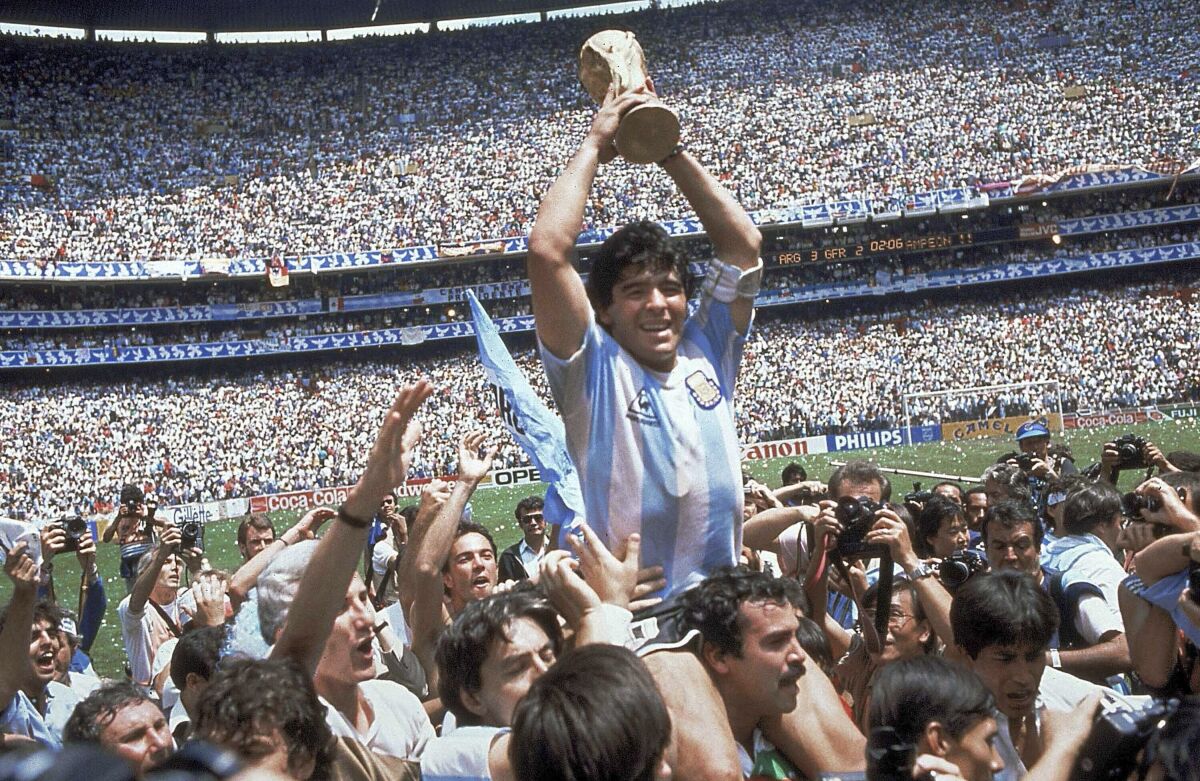 Diego Maradona holds up his team's trophy after Argentina's 3-2 victory over West Germany at the World Cup final in 1986.