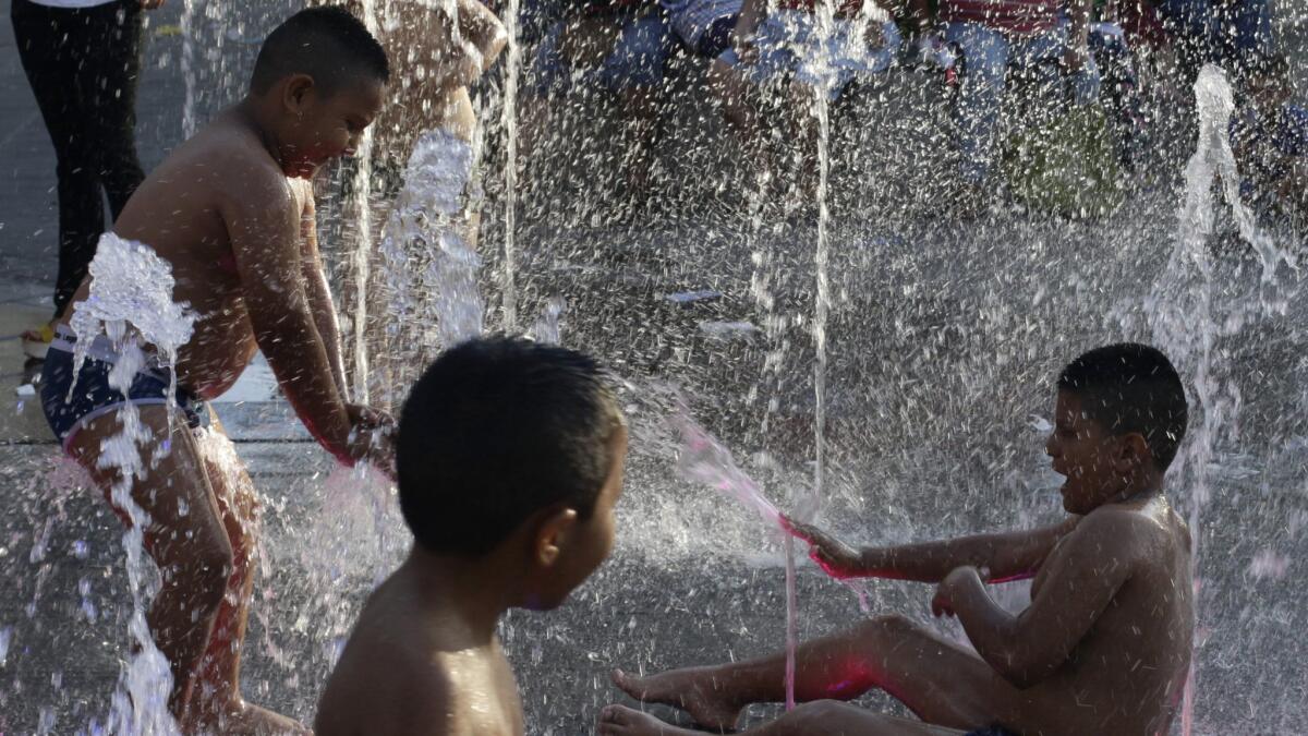 Children play in a water fountain in San Salvador, El Salvador, on Aug. 19.