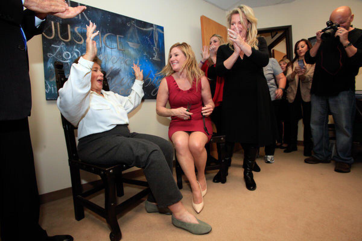 Lois Goodman, left, reacts after having her electronic monitoring device removed from her ankle by bail bondswoman Cynthia Stanley (in red) at her attorney's office in Sherman Oaks on Nov. 30, 2012. At far right is Alison Triessl, one of Goodman's attorneys. Earlier in the day, Goodman had all charges against her dropped at the Van Nuys Courthouse.