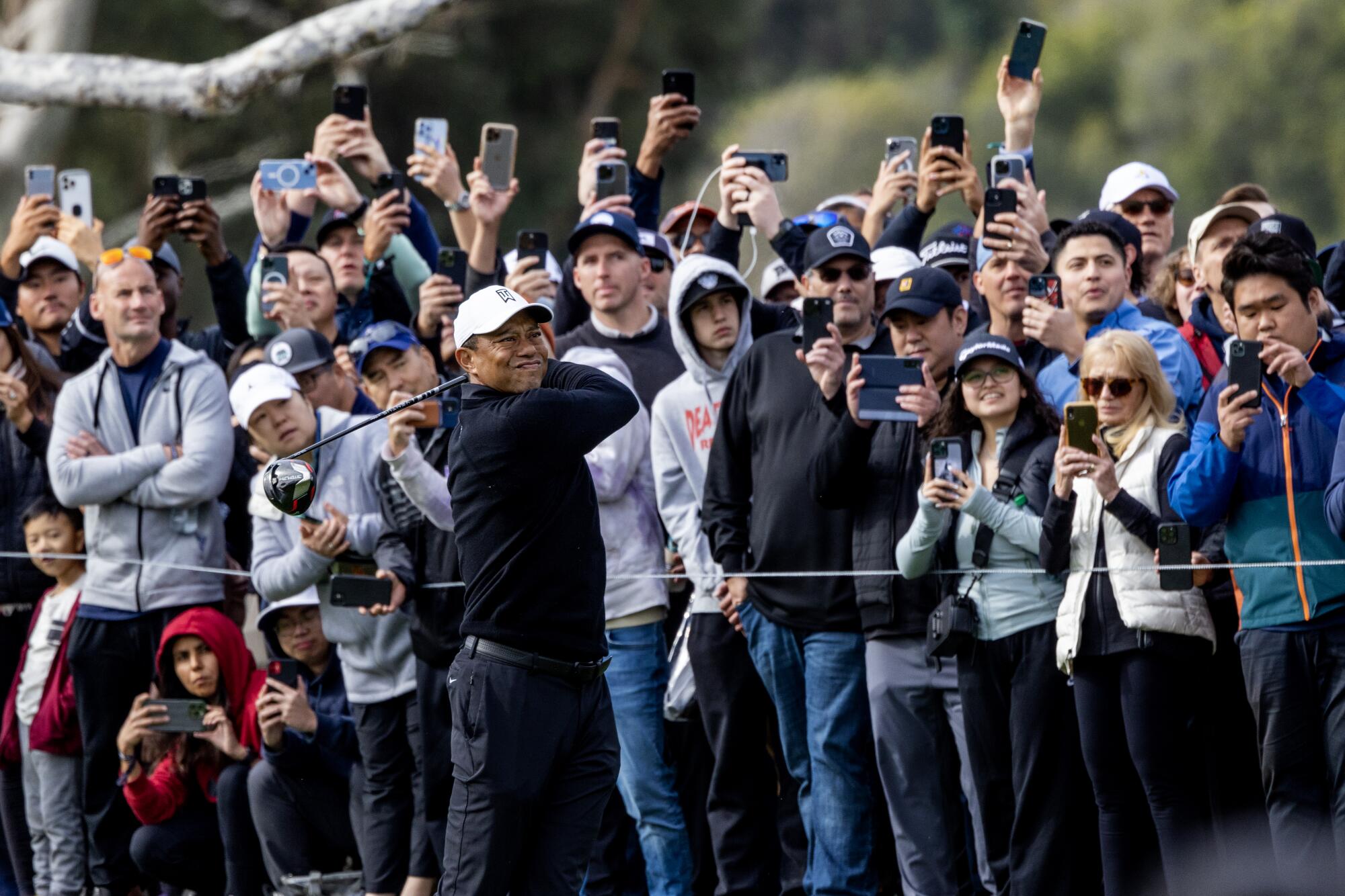 Tiger Woods tees off on the 18th hole in front of a large crowd during round two of the Genesis Invitational.