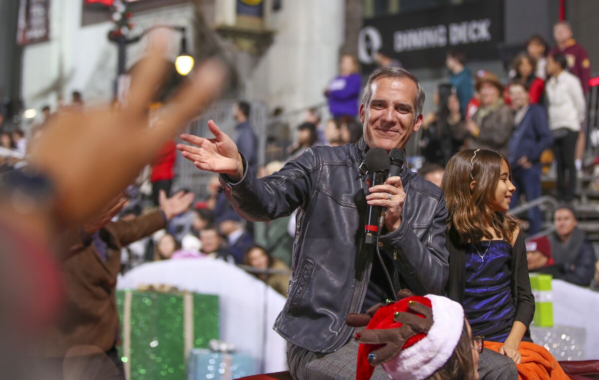 Outgoing Mayor Eric Garcetti rides in the Hollywood Christmas Parade with his daughter, Maya.