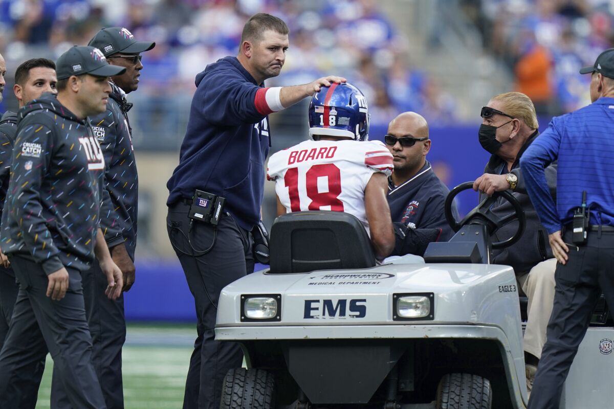 New York Giants head coach Joe Judge, center left, checks on C.J. Board as he is carted off the field during the first half of an NFL football game against the Los Angeles Rams, Sunday, Oct. 17, 2021, in East Rutherford, N.J. (AP Photo/Frank Franklin II)