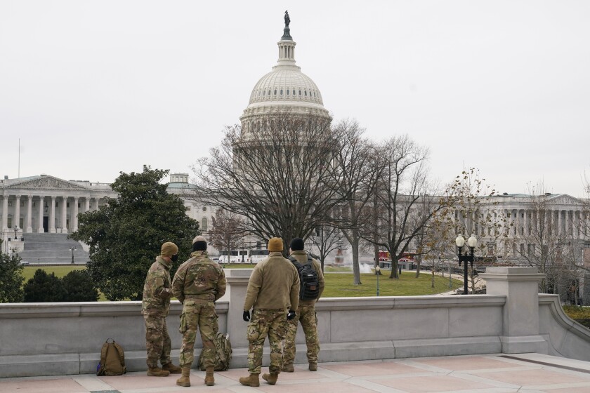 With the U.S. Capitol Building in view, members of the military stand on the steps of the Library of Congress' Thomas Jefferson Building in Washington, Friday, Jan. 8, 2021, in response to supporters of President Donald Trump who stormed the Capitol. (AP Photo/Patrick Semansky)