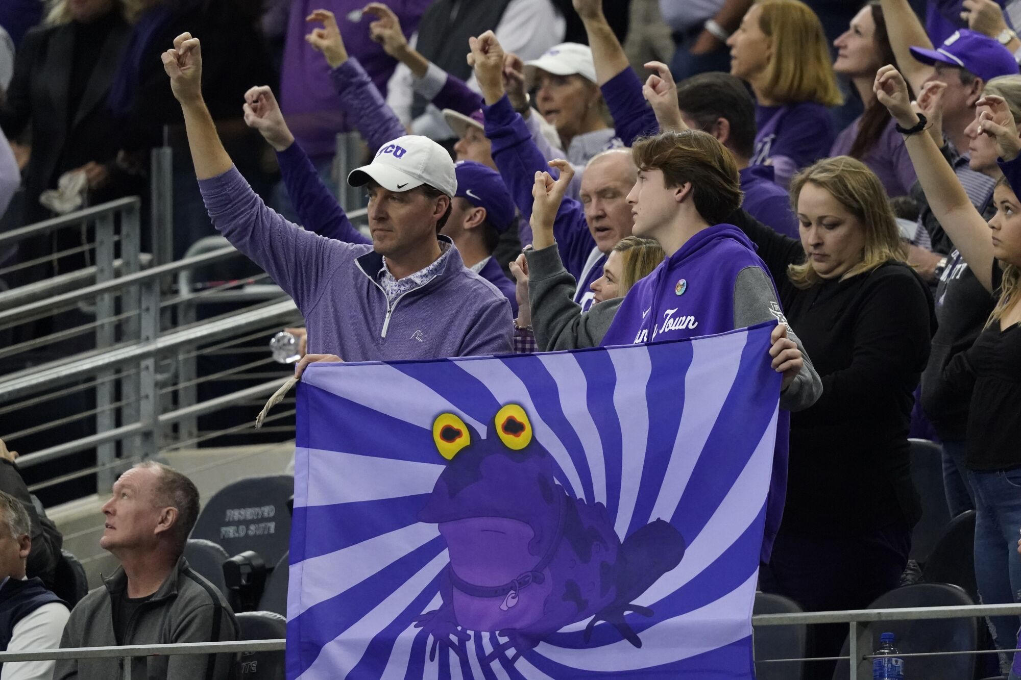 TCU fans hold up a hypnotoad flag and cheer during the Big 12 conference championship game