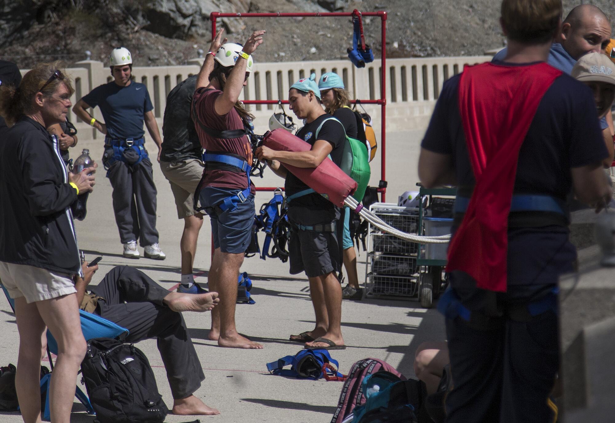 A person is fitted with a body harness before jumping off a bridge.