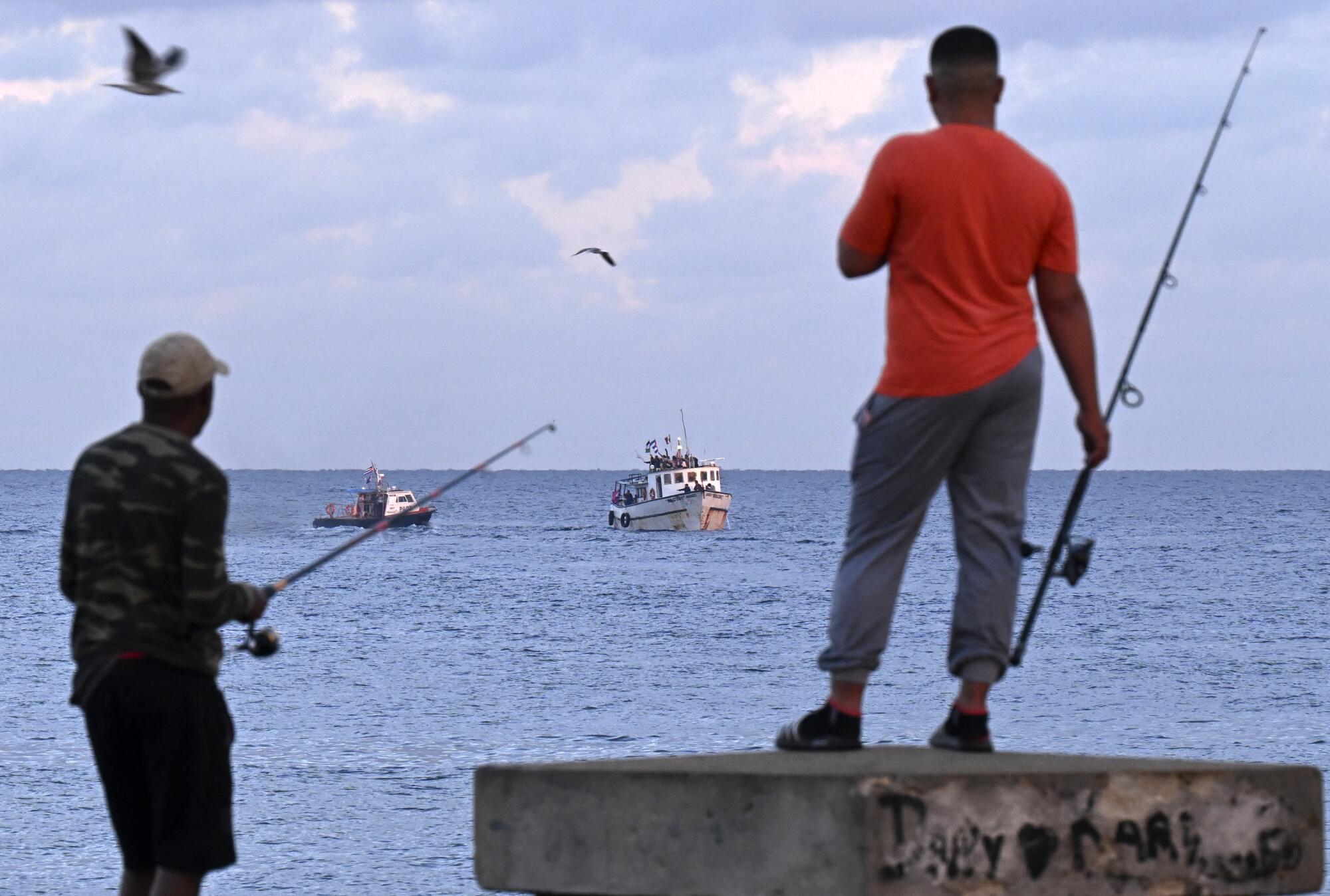 Men fish as the vessel Maguro arrives