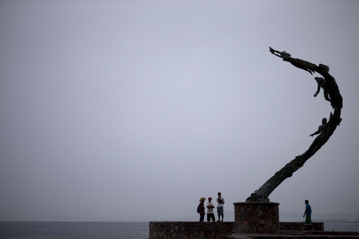 Vecinos visitando el paseo marítimo de Puerto Vallarta, México, antes de la llegada del huracán Patricia, el 23 de octubre de 2015. (AP Foto/Rebecca Blackwell)
