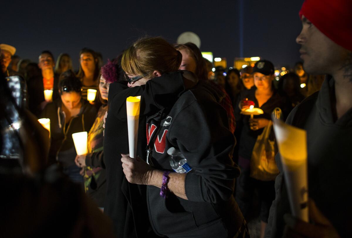 Allie Sibley of Upland, Calif., right, is comforted by a friend during a candle light vigil at Town Square to remember those killed and injured the day after a lone gunman open fired onto a county music festival on Oct. 2, 2017 in Las Vegas.