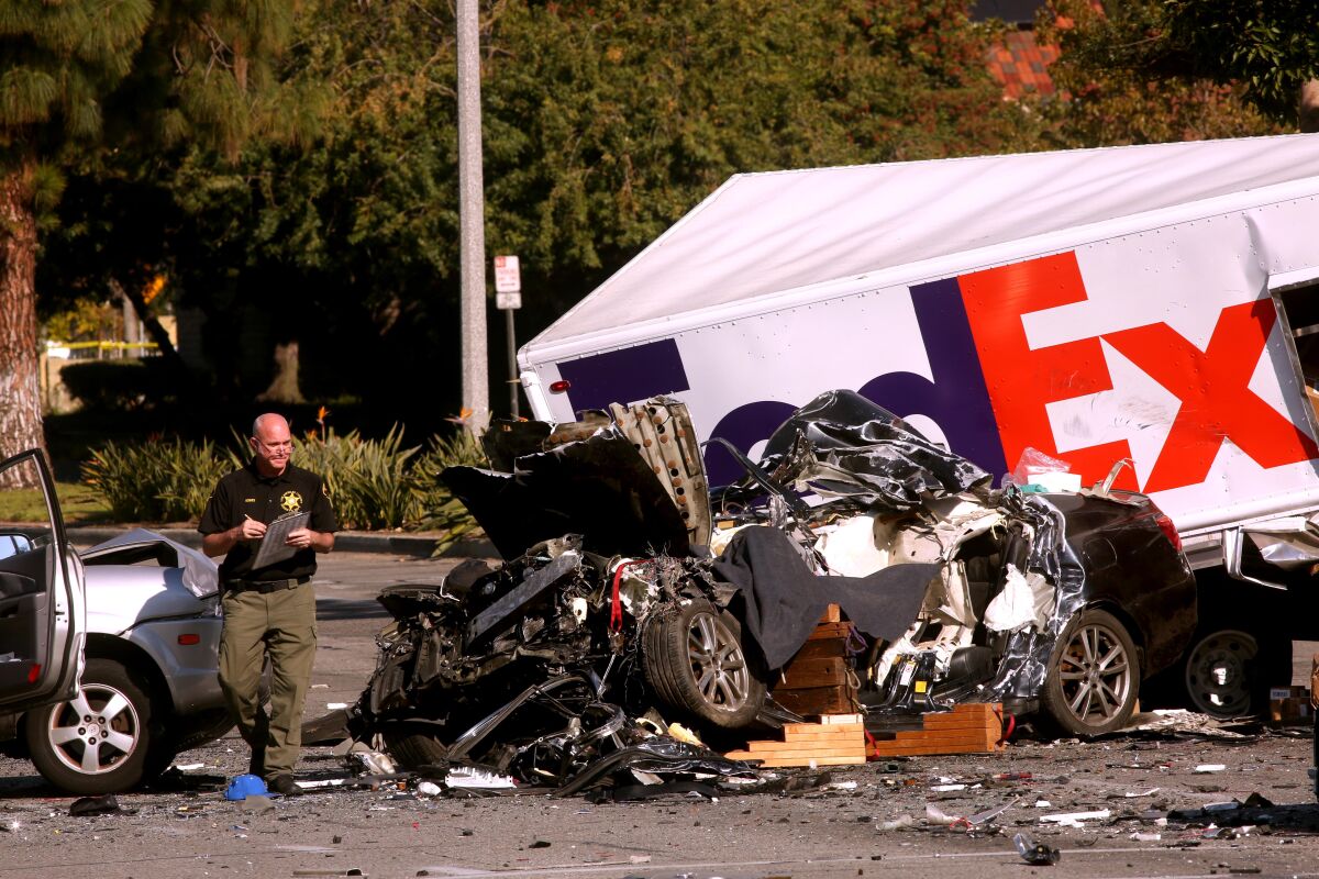 An L.A. County Sheriff's deputy investigates the scene of a six-vehicle crash involving a FedEx truck in Cerritos