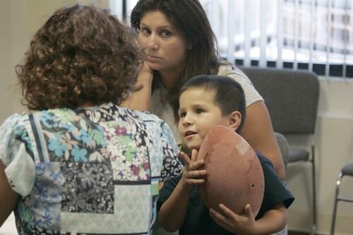 At a Lake Elsinore housing office, Kelly Porec, left, goes over paperwork with Ruth Cordoba, a 28-year-old mother of three who has brought along 3-year-old Joseph. Cordoba is trying to find another place to live after she and her children were evicted from a Section 8 rental that had fallen into foreclosure.