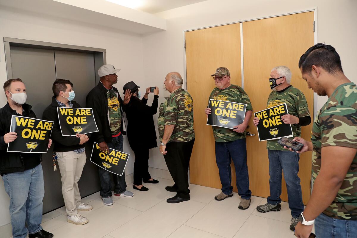 Union members stand outside of BlackRock's office front door as they protest against unfair labor practices.