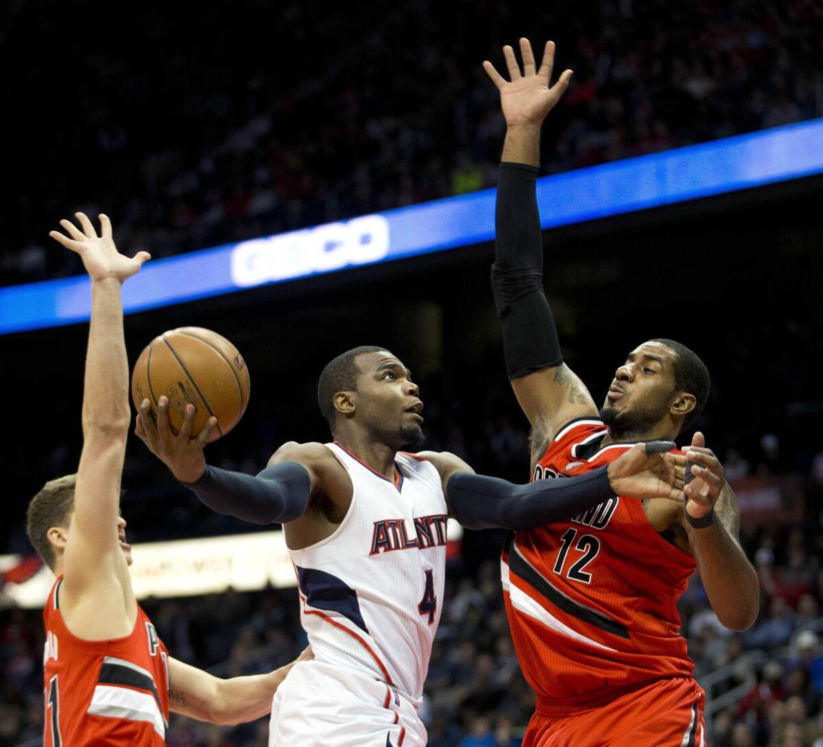 Atlanta;s Paul Millsap goes up for a basket against Portland's LaMarcus Aldridge during the first half of a game Jan. 30.