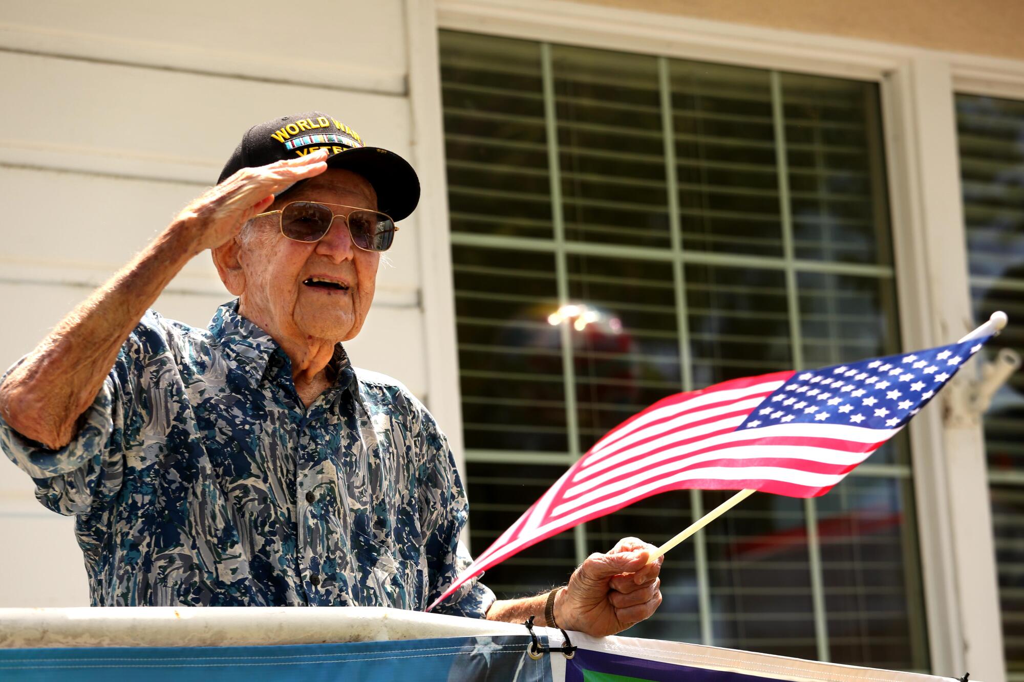Lt. Col. Sam Sachs, a World War II veteran, salutes well-wishers during a processional outside his Lakewood assisted living home to celebrate his 105th birthday.