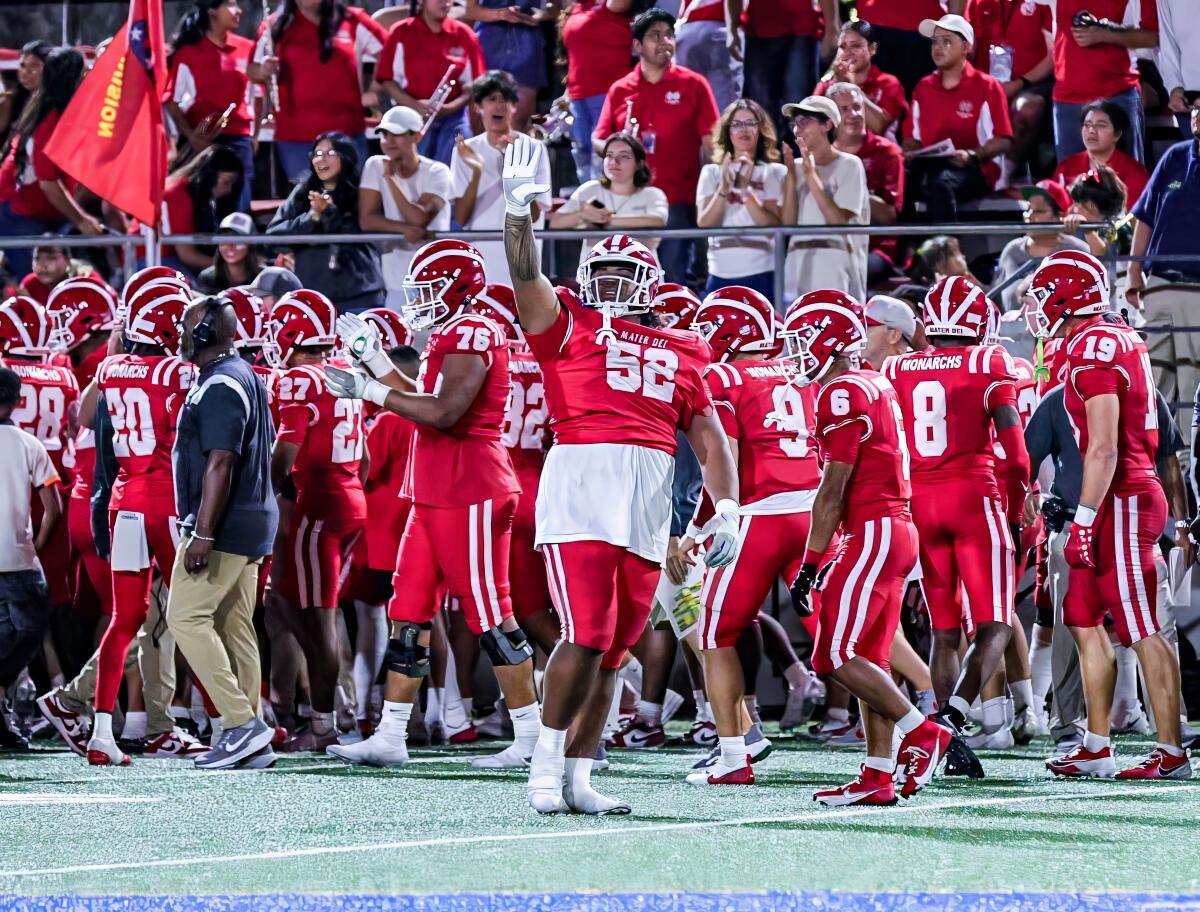 Mater Dei's Tomuhini Topui raises his right arm as the Monarchs begin to celebrate their win over Bishop Gorman.