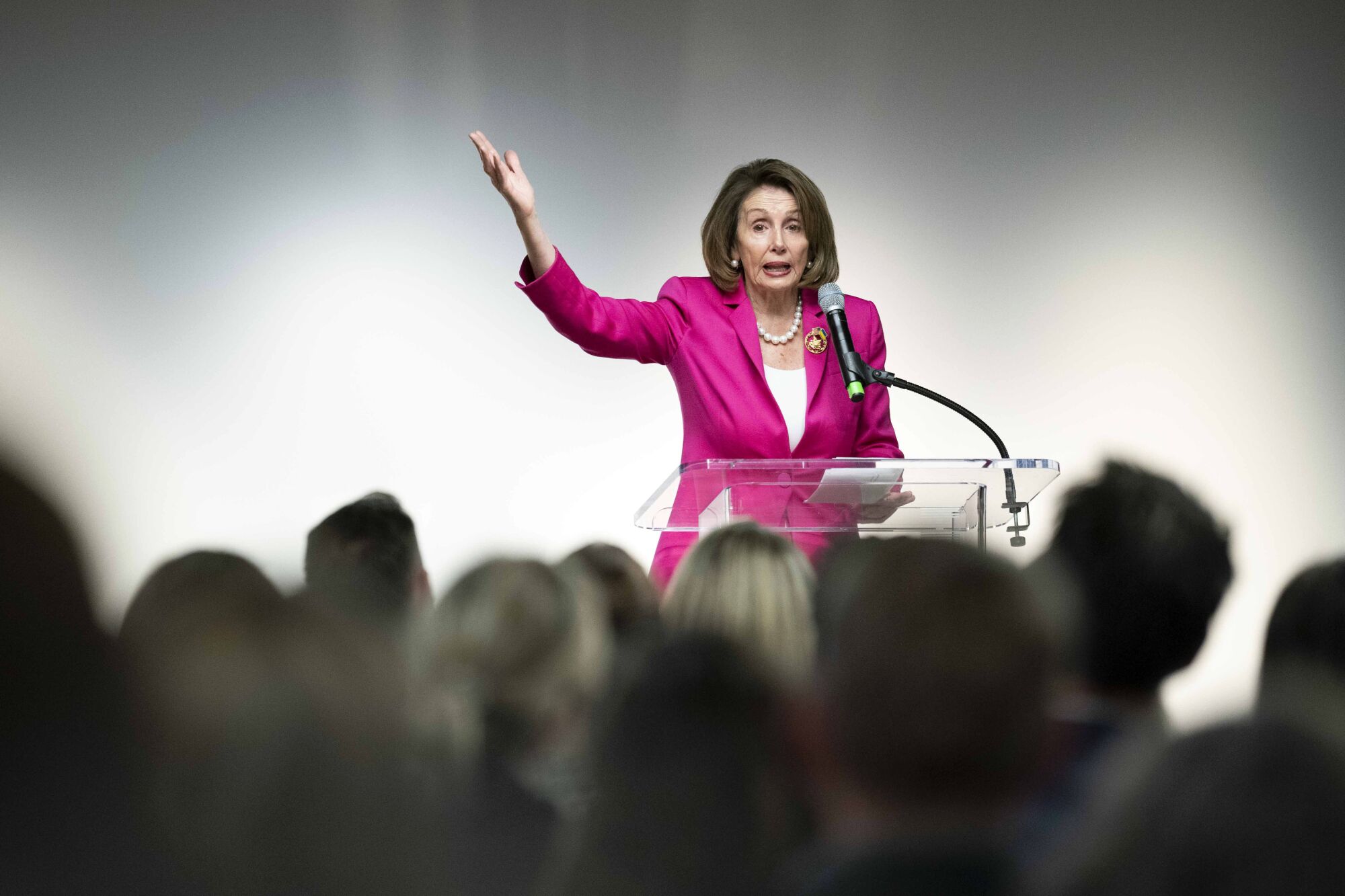 A woman gestures while speaking from a stage