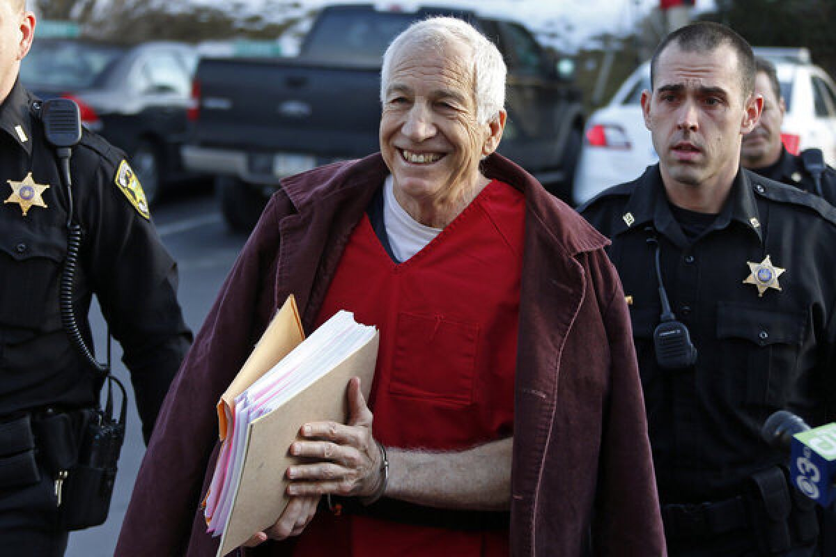 Former Penn State assistant football coach Jerry Sandusky, center, arrives at the Centre County Courthouse in Bellefonte, Pa., on Jan. 10 for a post-sentence motion.