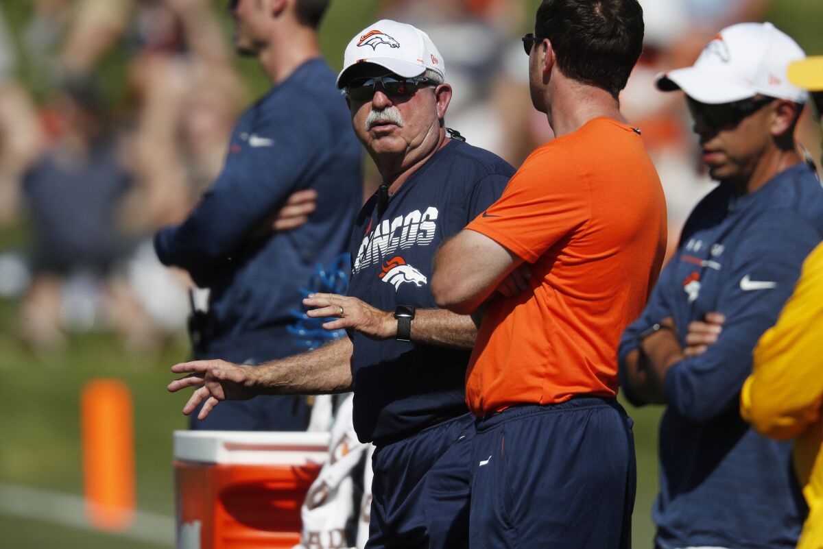 FILE - Denver Broncos trainer Steve Antonopulos, center, talks with staff members during drills at the team's NFL football training camp in Englewood, Colo., in this July 19, 2019, file photo. The Broncos announced on Monday, June 7, 2021, that Antonopulos will retire after more than three decades as the team's trainer. (AP Photo/David Zalubowski, File)
