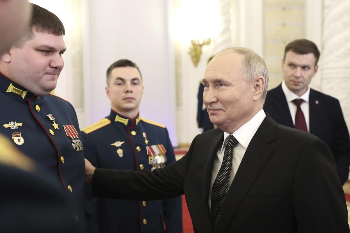 Russian President Vladimir Putin talks with Russian service members in the Grand Kremlin Palace in Moscow.