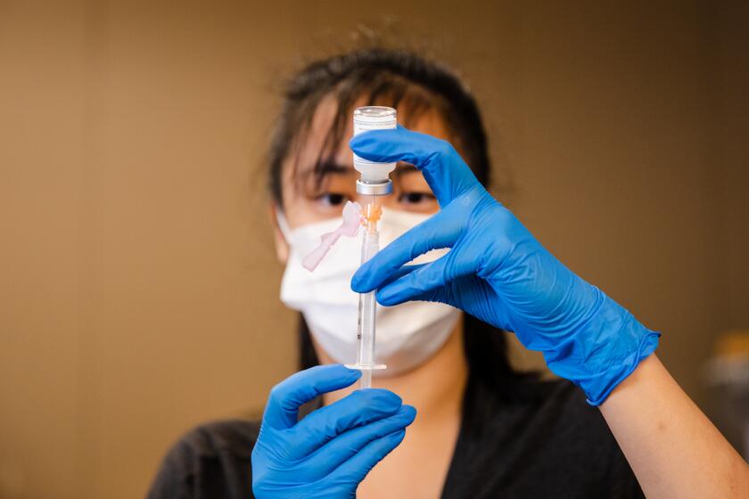Pharmacist Cinny Wong prepares Moderna vaccines at a converted former Sears building at Chula Vista Center on Monday, March 29.