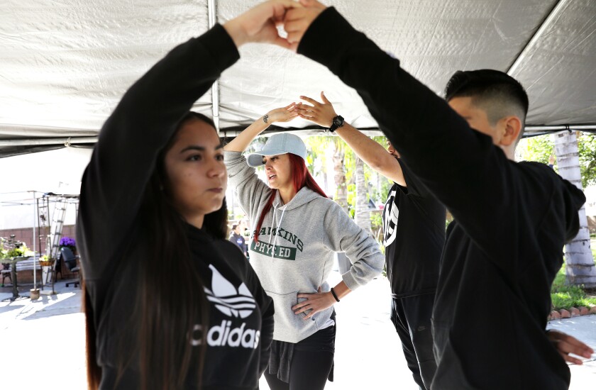 Choreographer Cynthia Garcia, center, teaches dance moves to a group of youngsters for an upcoming quinceañera for 14-year-old Ashley Soltero, in El Monte on Sunday.