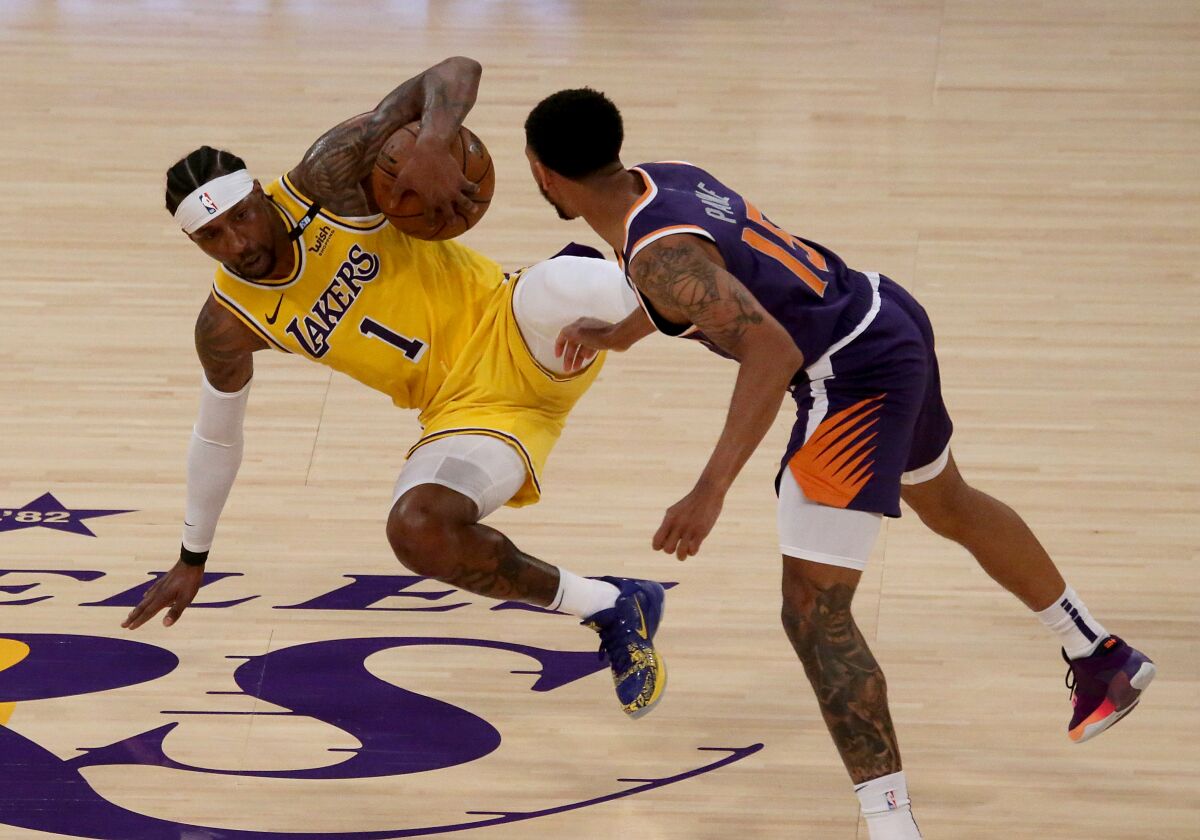 Lakers guard Kentavious Caldwell-Pope fights for control of the ball with Phoenix Suns guard Cameron Payne.