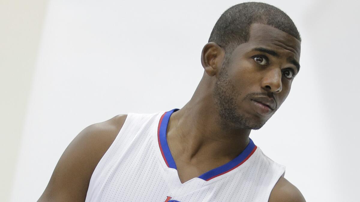 Clippers point guard Chris Paul poses for photos during the team's media day Monday. He says he learned a lot from his time playing Sam Cassell, now an assistant coach for the team.