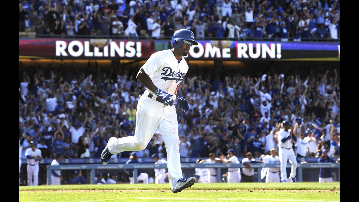 Dodgers shortstop Jimmy Rollins hits a go-ahead, three-run home run against the Padres in the eighth inning on opening day.